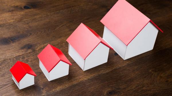 Different Size Houses in Row on Wooden Table